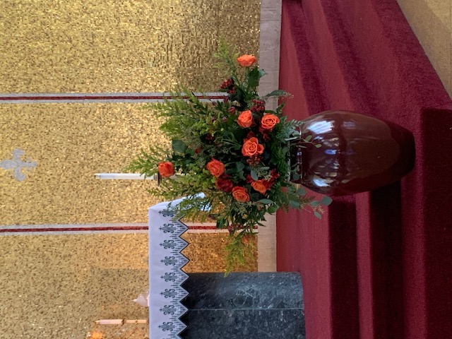 Orange and red rose church ceremony arrangement