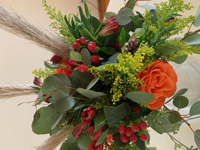Orange rose, red hypericum berry, and greenery bouquet