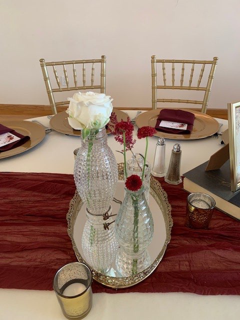 Bud vase centerpiece with single roses on a mirror tray