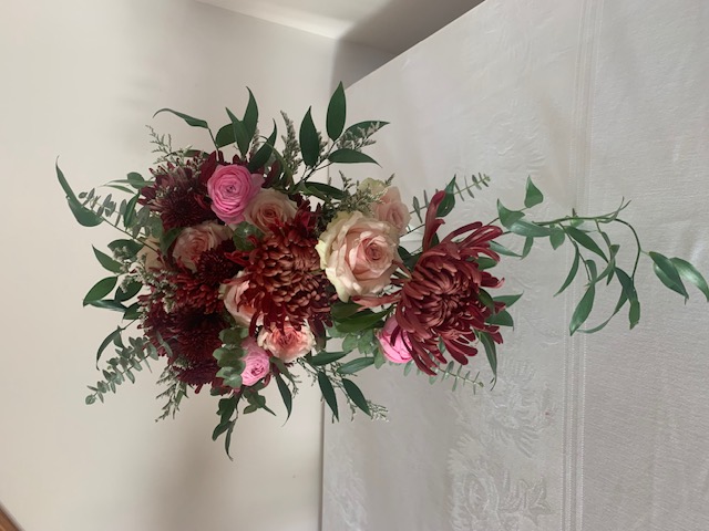 Burgundy mum, pink rose, and greenery cascade bouquet