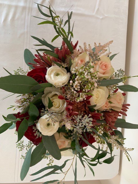 Burgundy, peach rose, and white ranunculus bridal bouquet
