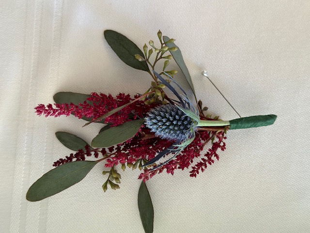Burgundy astilbe and thistle boutonniere