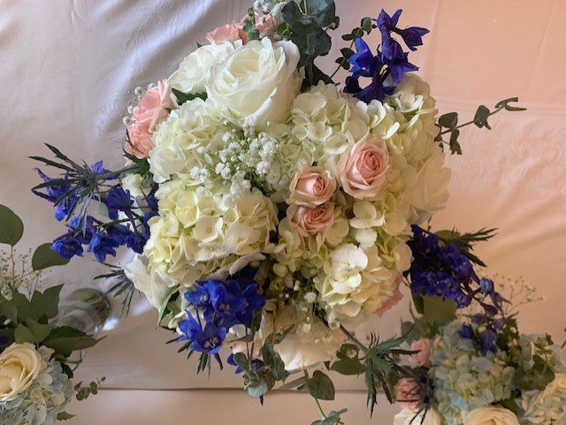 White hydrangea, blue delphinium, and pink rose bouquet