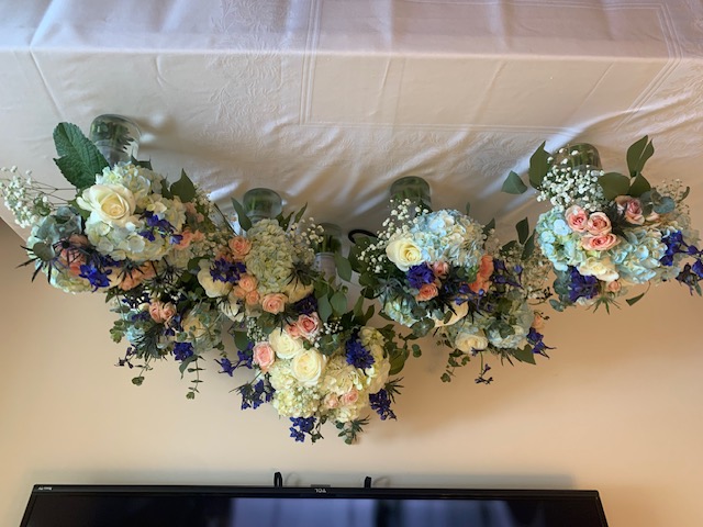 Light blue hydrangea, pink rose, and blue delphinium bridesmaid bouquets