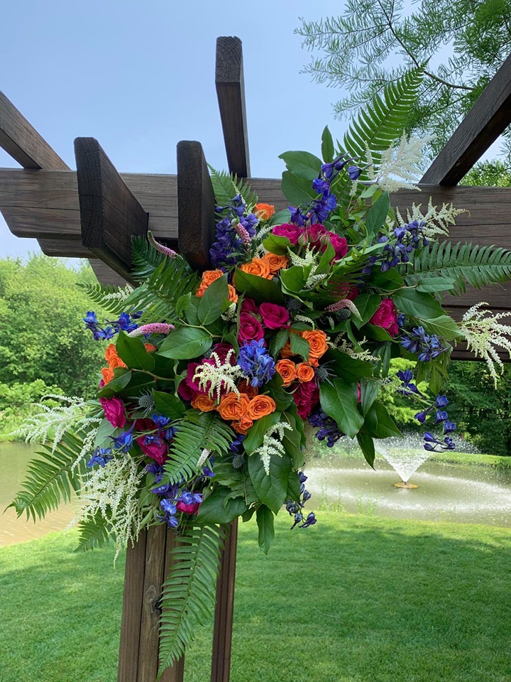 Orange and pink rose arbor swag with white astilbe