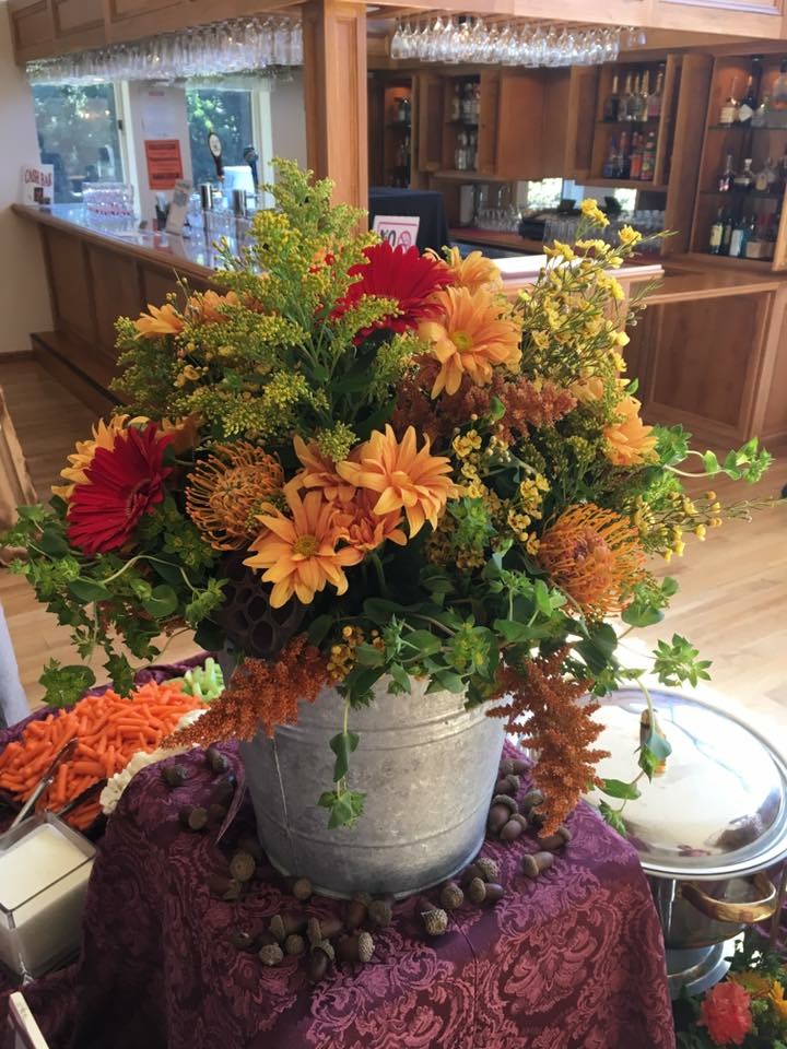 Pincushion mum, orange gerbera daisy, and solidago centerpiece