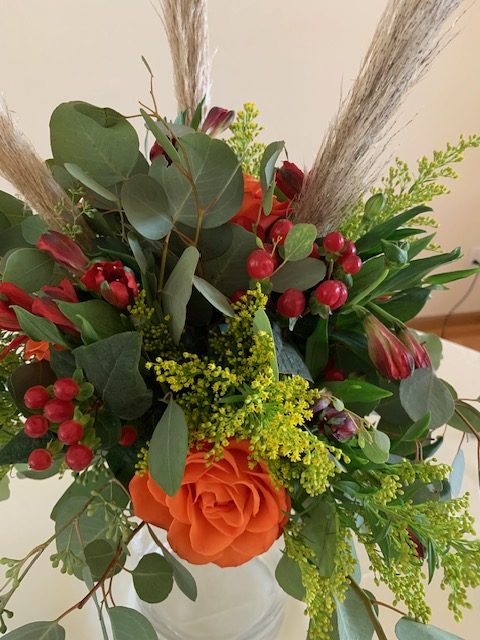 Orange rose, red hypericum berry, and greenery bouquet