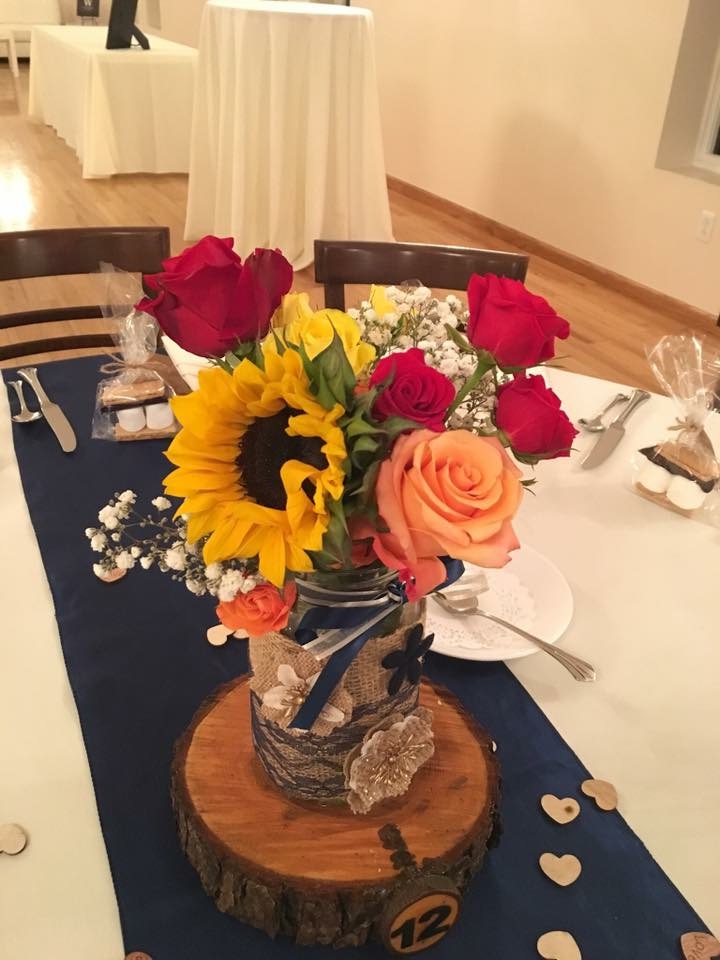 Sunflower, orange, and red rose centerpiece