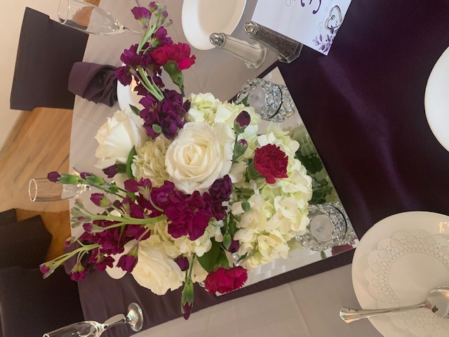 White hydrangea, purple stock, and white rose centerpiece