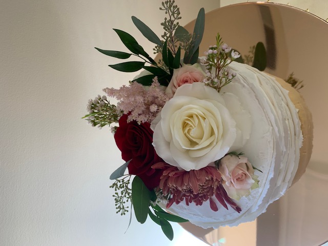 Fresh flower cake topper of white rose, sweetheart rose, and burgundy mum