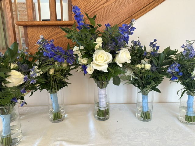 White rose and blue delphinium bridesmaid bouquets