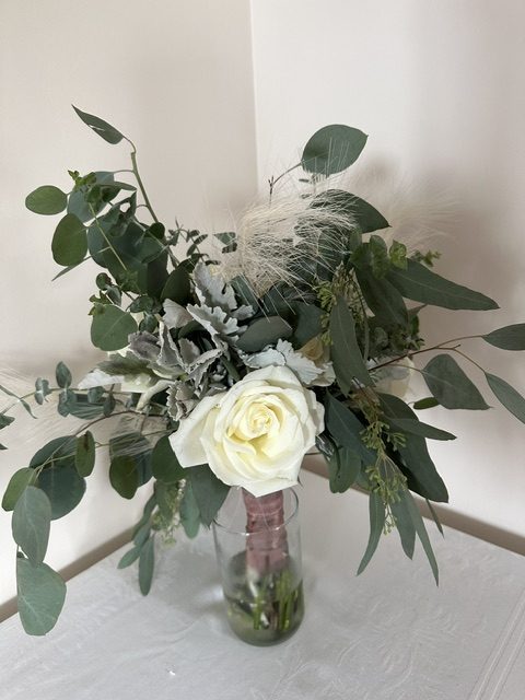 White rose bouquet with feathers and greenery